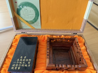 the same jade pillar with its stand separately stored in a soft orange fabric lined box
